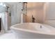 Freestanding tub and walk-in shower with wooden-look tile in this modern bathroom at 13508 Greenleaf Dr, Tampa, FL 33613