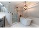 Bright bathroom featuring a standalone tub, walk-in shower, and a modern chandelier at 13508 Greenleaf Dr, Tampa, FL 33613