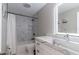 Modern bathroom featuring a marble-look shower and illuminated mirror over a matching vanity at 13508 Greenleaf Dr, Tampa, FL 33613