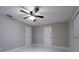 Bright bedroom with a ceiling fan and two doors, complemented by modern, marble-look flooring at 13508 Greenleaf Dr, Tampa, FL 33613