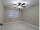 This bedroom features a ceiling fan and a bright window, complemented by modern, marble-look flooring at 13508 Greenleaf Dr, Tampa, FL 33613