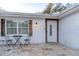 Exterior patio with decorative chairs by the window and a welcoming front door at 13508 Greenleaf Dr, Tampa, FL 33613