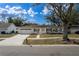 Charming single-story home with a well-manicured lawn, inviting front porch, and attached two-car garage at 13508 Greenleaf Dr, Tampa, FL 33613