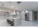 Bright kitchen featuring a marble island with bar seating, stainless steel fridge, and white cabinets at 13508 Greenleaf Dr, Tampa, FL 33613