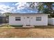 Rear view of outbuilding with white door, surrounded by a mix of gravel and lawn at 13508 Greenleaf Dr, Tampa, FL 33613