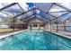 The pool is enclosed with a screen and features chairs for relaxing poolside at 13508 Greenleaf Dr, Tampa, FL 33613