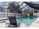 The screened in pool is adjacent to a building and is surrounded by a white fence at 13508 Greenleaf Dr, Tampa, FL 33613