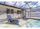 The pool area shows lounge chairs for relaxing by the screened-in pool at 13508 Greenleaf Dr, Tampa, FL 33613