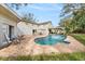 Backyard oasis with a freeform pool, lounge chairs, patio furniture, and mature trees at 14803 Tulip Dr, Tampa, FL 33613