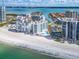 Aerial view of beachfront property with pool, condos and marina on a sunny day at 1590 Gulf Blvd # 501, Clearwater Beach, FL 33767