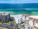 Aerial view of beachside condos, lush palm trees, a refreshing pool, and the turquoise ocean at 1590 Gulf Blvd # 501, Clearwater Beach, FL 33767