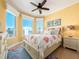 Bright bedroom features large bay windows with ocean views, ceiling fan, and stylish decor at 1590 Gulf Blvd # 501, Clearwater Beach, FL 33767