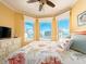 Bright bedroom features large bay windows with ocean views, ceiling fan, and light neutral walls at 1590 Gulf Blvd # 501, Clearwater Beach, FL 33767