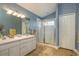 Well-lit bathroom featuring a double sink vanity and a glass-enclosed shower at 1788 Biarritz Cir, Tarpon Springs, FL 34689