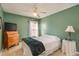 Green bedroom with a ceiling fan, wood dresser, and natural light at 1788 Biarritz Cir, Tarpon Springs, FL 34689