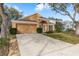 Well-maintained single-story home with lush landscaping, attached two-car garage, and inviting entryway at 1788 Biarritz Cir, Tarpon Springs, FL 34689