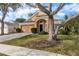 Charming single-story home featuring a well-manicured lawn, attached garage, and mature trees at 1788 Biarritz Cir, Tarpon Springs, FL 34689