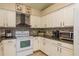 Well-lit kitchen with stainless steel appliances, granite countertops and mosaic tile backsplash at 1788 Biarritz Cir, Tarpon Springs, FL 34689