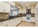 Bright kitchen featuring white cabinetry, granite countertops and a convenient breakfast bar at 1788 Biarritz Cir, Tarpon Springs, FL 34689