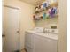 Functional laundry room equipped with a washer, dryer, and shelving for storage at 1788 Biarritz Cir, Tarpon Springs, FL 34689