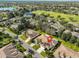 Aerial shot of a neighborhood with golf course, pond, mature trees, and well-manicured lawns at 1912 Acadia Greens Dr, Sun City Center, FL 33573