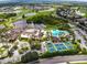 Aerial view of a community clubhouse featuring a pool, tennis courts, and mature landscaping at 1912 Acadia Greens Dr, Sun City Center, FL 33573