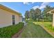 Manicured backyard with healthy green lawn, mature landscaping, and well-maintained exterior at 1912 Acadia Greens Dr, Sun City Center, FL 33573