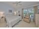 Bright bedroom features a ceiling fan, neutral carpet, a chair by the window, and neutral furniture at 1912 Acadia Greens Dr, Sun City Center, FL 33573