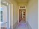 Open doorway into a home with a red door and a view of the kitchen at 1912 Acadia Greens Dr, Sun City Center, FL 33573