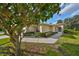 Landscaped front yard with stucco exterior, sidewalk, well maintained shrubbery, and healthy green lawn at 1912 Acadia Greens Dr, Sun City Center, FL 33573