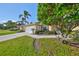 Single story house with meticulously kept lawn, palm trees, and red accent shutters at 1912 Acadia Greens Dr, Sun City Center, FL 33573