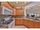 Kitchen with granite countertops, stainless steel sink, wood cabinets, and open layout to the living room at 1912 Acadia Greens Dr, Sun City Center, FL 33573