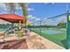 Outdoor tennis courts with seating area and shade canopies, perfect for an active lifestyle at 1912 Acadia Greens Dr, Sun City Center, FL 33573