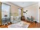 Bedroom with hardwood floors, white crib, and natural lighting from windows at 1924 W Carmen St, Tampa, FL 33606