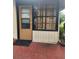 A functional entrance featuring a door with blinds, and a window with decorative curtains above a tiled area at 2209 Canterbury Ln, Sun City Center, FL 33573