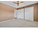 Bedroom featuring a light ceiling fan, neutral carpet, tan painted walls, and closet at 2293 Swedish Dr # 37, Clearwater, FL 33763