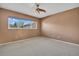 Bedroom featuring a light ceiling fan, neutral carpet, tan painted walls, and window with view at 2293 Swedish Dr # 37, Clearwater, FL 33763