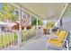 Inviting covered porch with yellow cushioned seating and lush green foliage at 2298 Americus E Blvd # 6, Clearwater, FL 33763