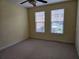 Bright bedroom features neutral carpet and a ceiling fan, bathed in natural light from two windows at 2755 Via Capri Dr # 1215, Clearwater, FL 33764