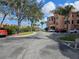 Condominium exterior featuring covered parking, palm trees, and well-maintained landscaping at 2755 Via Capri Dr # 1215, Clearwater, FL 33764