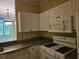 Well-lit kitchen featuring granite counters and classic white appliances for a functional cooking experience at 2755 Via Capri Dr # 1215, Clearwater, FL 33764