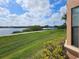 Scenic lake view featuring a walking path, lush green grass, and blue skies at 2755 Via Capri Dr # 1215, Clearwater, FL 33764