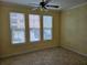 Bright living room features tile flooring and a ceiling fan, bathed in natural light from three large windows at 2755 Via Capri Dr # 1215, Clearwater, FL 33764