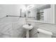 Bathroom featuring white tiles and a pedestal sink, creating a sleek aesthetic at 2786 Countryside Blvd # 2, Clearwater, FL 33761