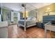 Bedroom with four-poster bed, tile flooring, window with plantation shutters, and side tables at 2786 Countryside Blvd # 2, Clearwater, FL 33761