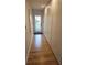 Hallway with wood flooring and storage running length of wall to an exterior door at 29318 Whipporwill Ln, Wesley Chapel, FL 33543