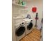 Functional laundry room with modern washer, dryer, and ample shelving at 29318 Whipporwill Ln, Wesley Chapel, FL 33543