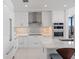 Modern kitchen featuring white cabinetry, stainless steel appliances, a mosaic backsplash, and ample counter space at 301 1St S St # 2104, St Petersburg, FL 33701