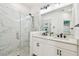 Modern bathroom featuring a glass-enclosed shower, double vanity, and contemporary fixtures at 310 Blackrock Ln, Apollo Beach, FL 33572