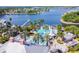 Aerial view of the community pool area, with a lighthouse, lounge chairs, and beautiful palm trees at 310 Blackrock Ln, Apollo Beach, FL 33572